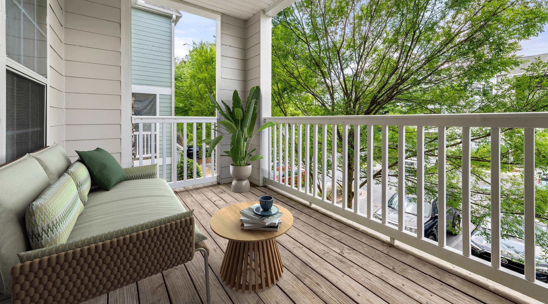 a deck with a couch and a table and a tree
